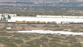 HD aerial stock footage of a train passing a warehouse in El Paso, Texas Aerial Stock Footage | AF0001_000918