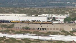 HD aerial stock footage of a train passing a large warehouse building in El Paso, Texas Aerial Stock Footage | AF0001_000919