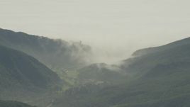 5K aerial stock footage of fog rolling over green mountains and reveal suburban homes in Los Angeles, California Aerial Stock Footage | AF0001_000974