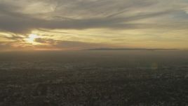 5K aerial stock footage of urban neighborhoods and Downtown Los Angeles skyline seen from Santa Fe Springs, California at sunset Aerial Stock Footage | AF0001_000976
