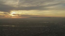 5K aerial stock footage of setting sun behind clouds and Downtown Los Angeles skyline seen from Whittier, California Aerial Stock Footage | AF0001_000979