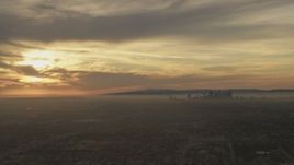 5K aerial stock footage of the setting sun behind clouds and the Downtown Los Angeles skyline, California Aerial Stock Footage | AF0001_000983
