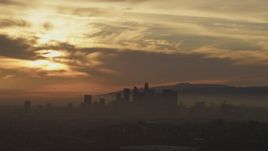 5K aerial stock footage of a view of sunset and clouds above the hazy Downtown Los Angeles skyline, California Aerial Stock Footage | AF0001_000988
