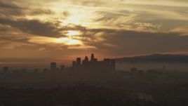 5K aerial stock footage of the sunset and clouds over the hazy Downtown Los Angeles skyline, California Aerial Stock Footage | AF0001_000989