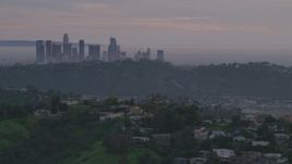 5K aerial stock footage of Downtown Los Angeles skyline seen while flying by hillside homes at twilight, California Aerial Stock Footage | AF0001_001000