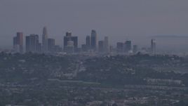 5K aerial stock footage of a view of Downtown Los Angeles skyline behind hillside houses in Silver Lake at twilight, California Aerial Stock Footage | AF0001_001005