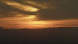 5K aerial stock footage of the sunset lighting up the clouds over Los Angeles mountains, California Aerial Stock Footage | AF0001_001010