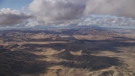 8K aerial stock footage fly over desert hills beneath clouds in Southern California Aerial Stock Footage | AF0001_001020