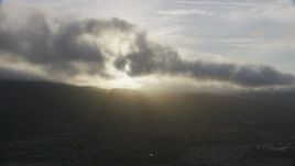8K aerial stock footage of thick clouds over mountains and suburban homes at sunset in Southern California Aerial Stock Footage | AF0001_001028