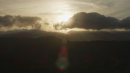 8K aerial stock footage of setting sun behind clouds over mountains in Southern California Aerial Stock Footage | AF0001_001030