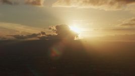 8K aerial stock footage of setting sun behind clouds as a helicopter passes in Southern California Aerial Stock Footage | AF0001_001032