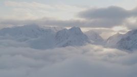 4K aerial stock footage pan by snow covered peaks above low clouds, Chugach National Forest, Alaska Aerial Stock Footage | AK0001_0010