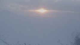 4K aerial stock footage approaching sun peeking through low clouds, Chugach Mountains, Alaska, sunset Aerial Stock Footage | AK0001_0081