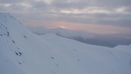 4K aerial stock footage snow covered mountain peak, reveal valley, Chugach Mountains, Alaska, sunset Aerial Stock Footage | AK0001_0083