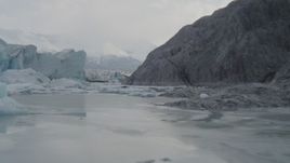 4K aerial stock footage flying low over icy Knik River, tilt up, revealing Knik Glacier, Alaska Aerial Stock Footage | AK0001_0116