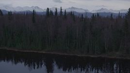 4K aerial stock footage over wooded shoreline, reveal Downtown Anchorage, Point MacKenzie, Alaska Aerial Stock Footage | AK0001_0173