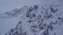 4K aerial stock footage fly over summit toward a snow covered range, Chugach Mountains, Alaska, sunset Aerial Stock Footage | AK0001_0188