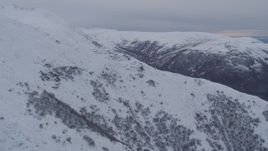 4K aerial stock footage flying over snow covered slope, revealing valley, Chugach Mountains, Alaska Aerial Stock Footage | AK0001_0233