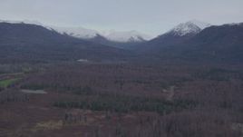 4K aerial stock footage flying over forested foothills, approaching snow capped Chugach Mountains, Alaska Aerial Stock Footage | AK0001_0247
