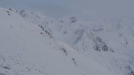 4K aerial stock footage flying by snowy slope, revealing Chugach Mountains, Alaska Aerial Stock Footage | AK0001_0261