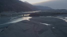 4K aerial stock footage lift off shore, follow Knik River, Old Glenn Highway bridge, Knik River, Alaska, sunset Aerial Stock Footage | AK0001_0303