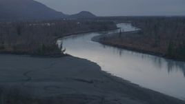 4K aerial stock footage flying over Knik River, tree lined river banks, Alaska, twilight Aerial Stock Footage | AK0001_0307