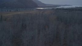 4K aerial stock footage flying over the forest, revealing two bridges spanning the Knik River, Alaska, twilight Aerial Stock Footage | AK0001_0313