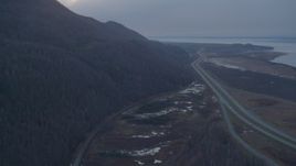 4K aerial stock footage flying over Glenn Highway, pan right to reveal highway, Knik River, Alaska, twilight Aerial Stock Footage | AK0001_0314