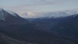 4K aerial stock footage flying by valley bordered by snowy Chugach Mountains, Alaska, twilight Aerial Stock Footage | AK0001_0317