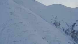 4K aerial stock footage flying low over snowy slopes, Chugach Mountains, Alaska, twilight Aerial Stock Footage | AK0001_0321