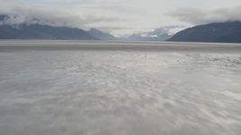 4K aerial stock footage flying low over the water, tilt up, revealing Turnagain Arm of the Cook Inlet, Alaska Aerial Stock Footage | AK0001_0371