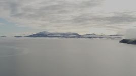 4K aerial stock footage flying low over the bay covered in low clouds, Prince William Sound, Alaska Aerial Stock Footage | AK0001_0411