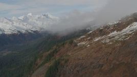 4K aerial stock footage flying over rocky slopes, under clouds, into mountains, Prince William Sound, Alaska Aerial Stock Footage | AK0001_0421