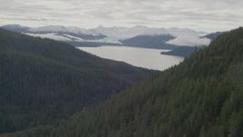 4K aerial stock footage flying between forested peaks, approaching a bay, Prince William Sound, Alaska Aerial Stock Footage | AK0001_0426