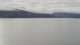 4K aerial stock footage crossing a bay, approach forested peaks, clouds, Prince William Sound, Alaska Aerial Stock Footage | AK0001_0429