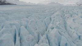 4K aerial stock footage tilt up from surface of glacier, reveal snowy peaks, Prince William Sound, Alaska Aerial Stock Footage | AK0001_0437