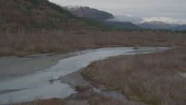 4K aerial stock footage flying low over river through grassland to shore, Prince William Sound, Alaska Aerial Stock Footage | AK0001_0454
