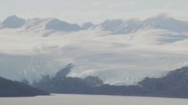 4K aerial stock footage a glacier spilling down from mountains to shore, Blackstone Bay, Alaska Aerial Stock Footage | AK0001_0463