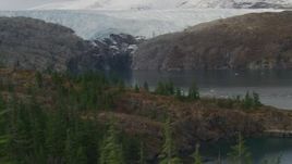 4K aerial stock footage flying over edge of island, pan to reveal glacier, Blackstone Bay, Alaska Aerial Stock Footage | AK0001_0477