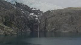 4K aerial stock footage approach small waterfall beneath glacier, rocky edge, Blackstone Bay, Alaska Aerial Stock Footage | AK0001_0478