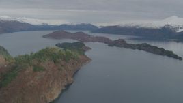 4K aerial stock footage flying by island, surrounded by snow capped mountains, Blackstone Bay, Alaska Aerial Stock Footage | AK0001_0480