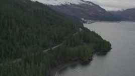 4K aerial stock footage flying along wooded shoreline and forest road, approaching Whittier, Alaska Aerial Stock Footage | AK0001_0498