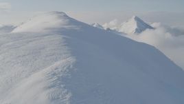 4K aerial stock footage flying through low clouds up the summit of a peak, Kenai Mountains, Alaska Aerial Stock Footage | AK0001_0534