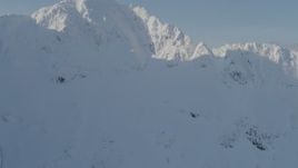 4K aerial stock footage flying over snowy ridge, revealing mountain peaks, Kenai Mountains, Alaska Aerial Stock Footage | AK0001_0538