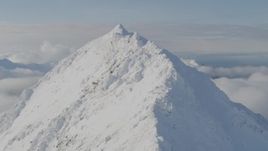 4K aerial stock footage ascending snowy peak, reveal low clouds, snowy Kenai Mountains, Alaska Aerial Stock Footage | AK0001_0545