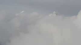 4K aerial stock footage flying over low clouds, approaching snowy summits, Chugach Mountains, Alaska Aerial Stock Footage | AK0001_0556