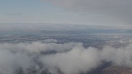 4K aerial stock footage flying by low clouds over Anchorage, from Chugach Mountains, Anchorage, Alaska Aerial Stock Footage | AK0001_0567