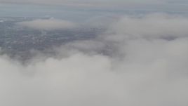 4K aerial stock footage tilt up from thick clouds, revealing Downtown Anchorage, Alaska Aerial Stock Footage | AK0001_0578