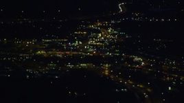 4K aerial stock footage flying by blurred lights, clearing to reveal city, city roads, Anchorage, Alaska, night Aerial Stock Footage | AK0001_0604