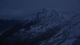 4K aerial stock footage flying by snowy Chugach Mountains, pan to river valley, Palmer, Alaska, sunrise Aerial Stock Footage | AK0001_0614